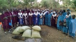 Women's and men's groups receiving gifts of ground maize from Maasai Education Foundation representatives